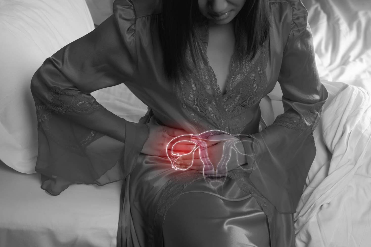 Mujer con camisón de seda y bata de encaje con dolor uterino