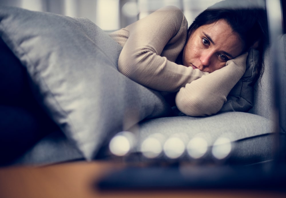 mujer deprimida acostada en la cama