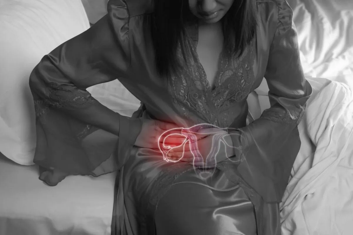 Woman in silk nightgown and lace robe with uterus pain