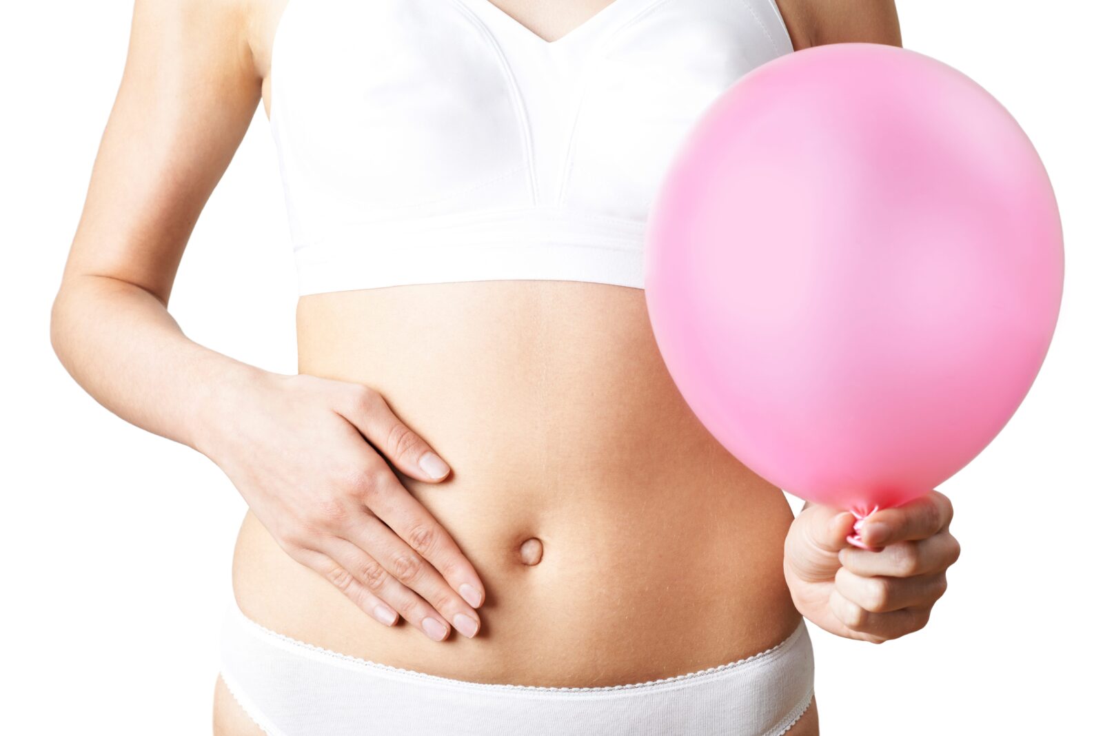 woman holding her stomach with a balloon in her other hand to represent bloating
